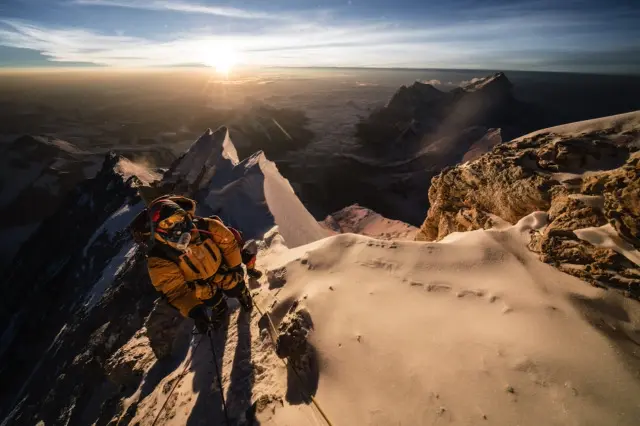 Alpinista en cumbre nevada