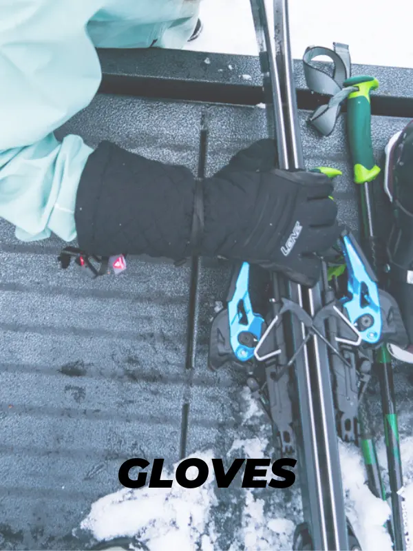 Persona con guante cogiendo los esquís