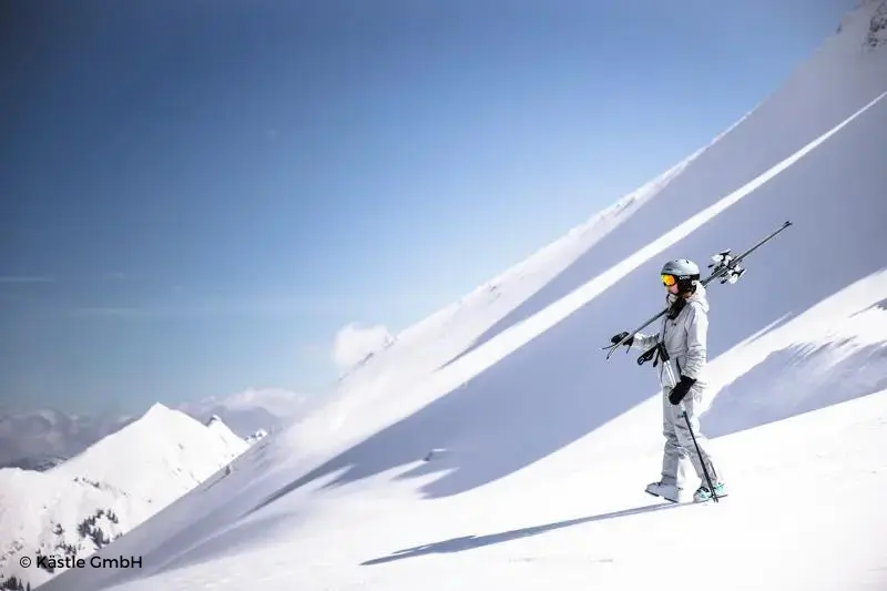 Ladera de montaña nevada con esquiadora