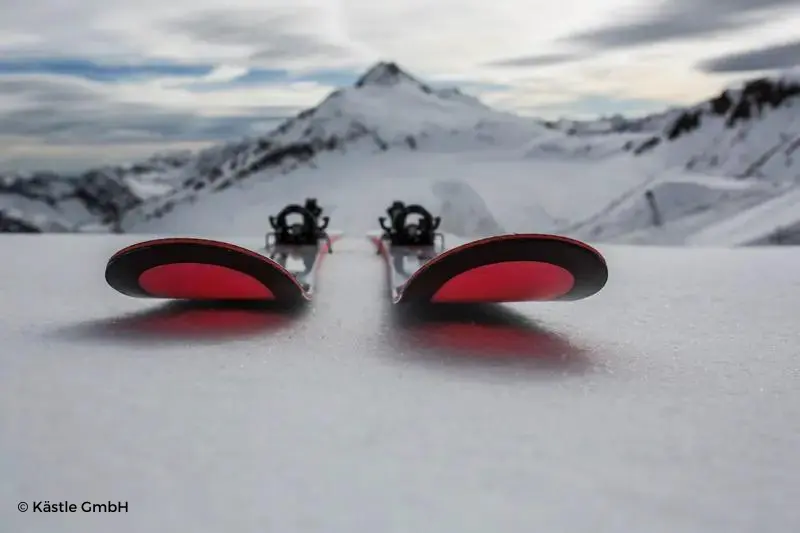 Esquís rojos de Kästle con un fondo montañoso